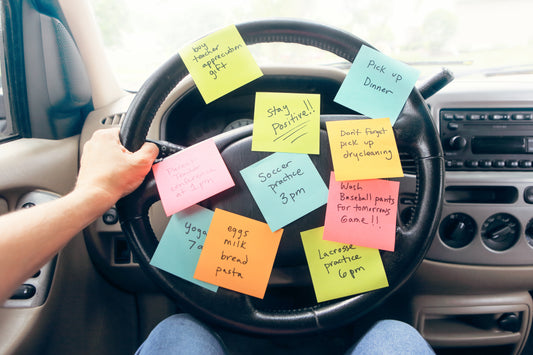 a lot of sticky note reminders stuck to a steering wheel