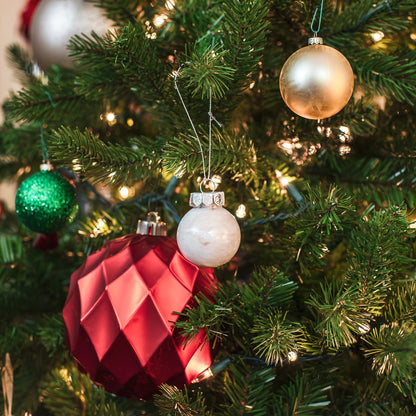 White homemade ornament on a Christmas tree branch.