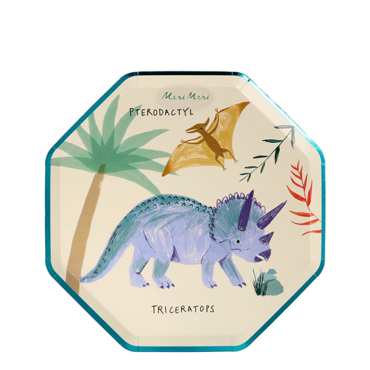 A small octagonal Meri Meri plate illustrated with a blue triceratops and a golden pterodactyl amongst some rocks, leaves, and a palm tree.